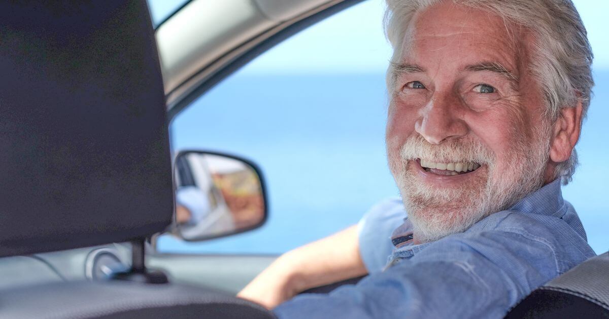 Happy man smiling in a car